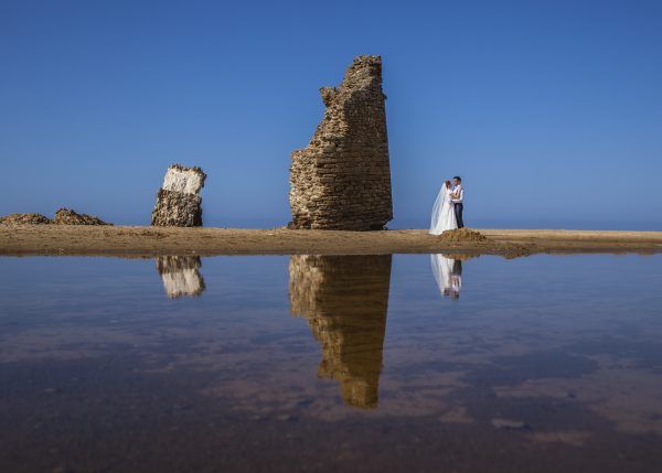 Fotografía de una pareja de novios en el mar en su reportaje fotográfico.