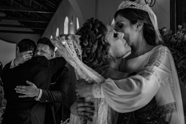 Novio abrazando al padrino y la novia abrazando a la madrina.