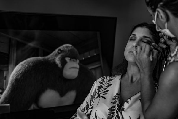 Fotografía de los preparativos de la novia con una imagen divertida de fondo.