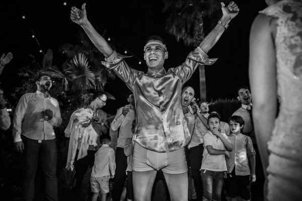 Fotografía divertida del novio quitándose la ropa.