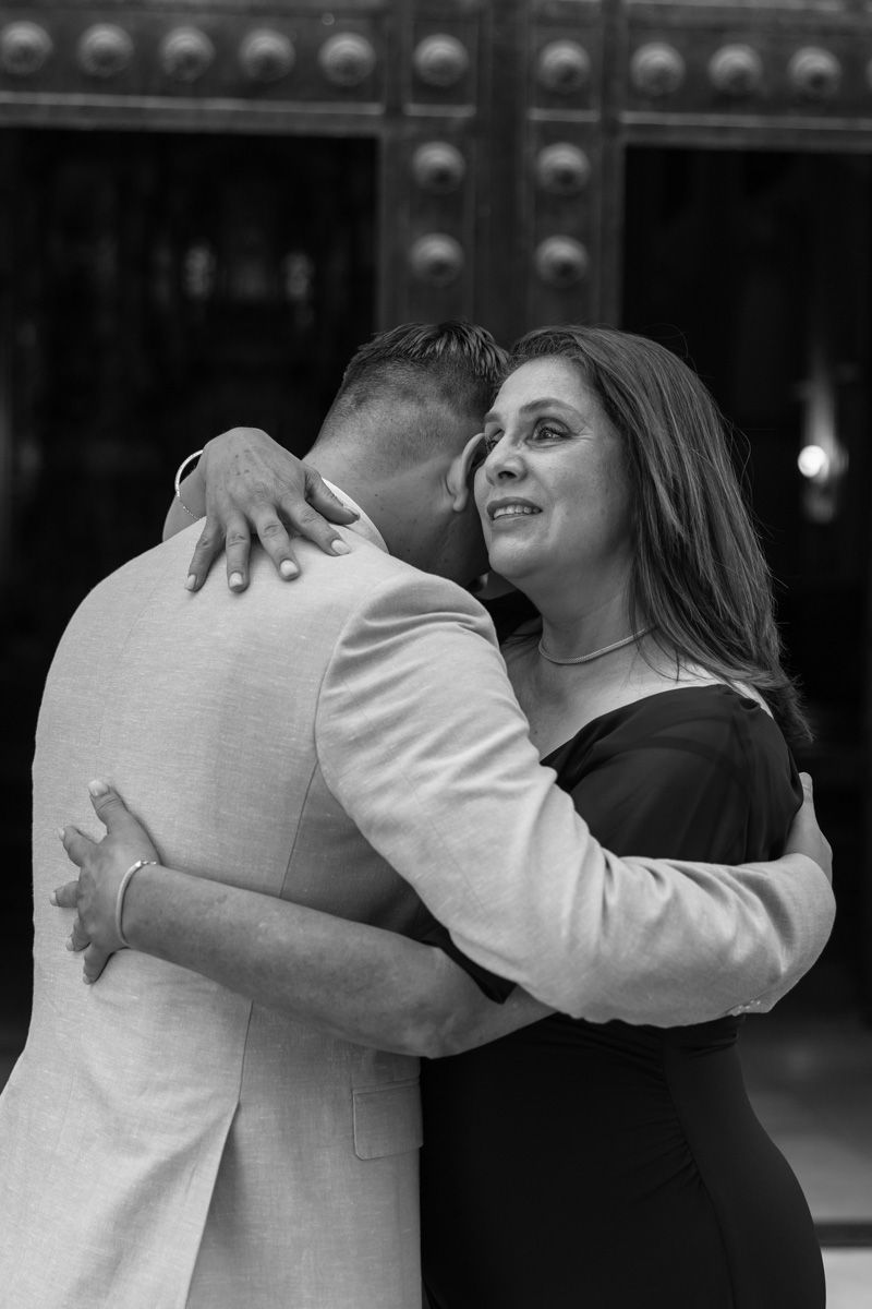 Foto en blanco y negro de un bonito abrazo de madre a su hijo el novio.