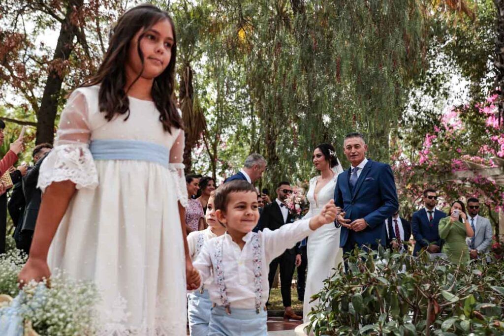Niños delante del padrino y la novia en la entrada a la ceremonia.