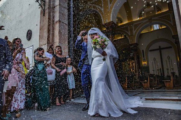 fotografía de unos novios saliendo de la iglesisa